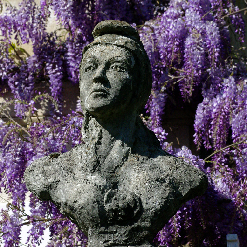 Marianne béton sur fond de glycines . Sculpture de Philippe Doberset