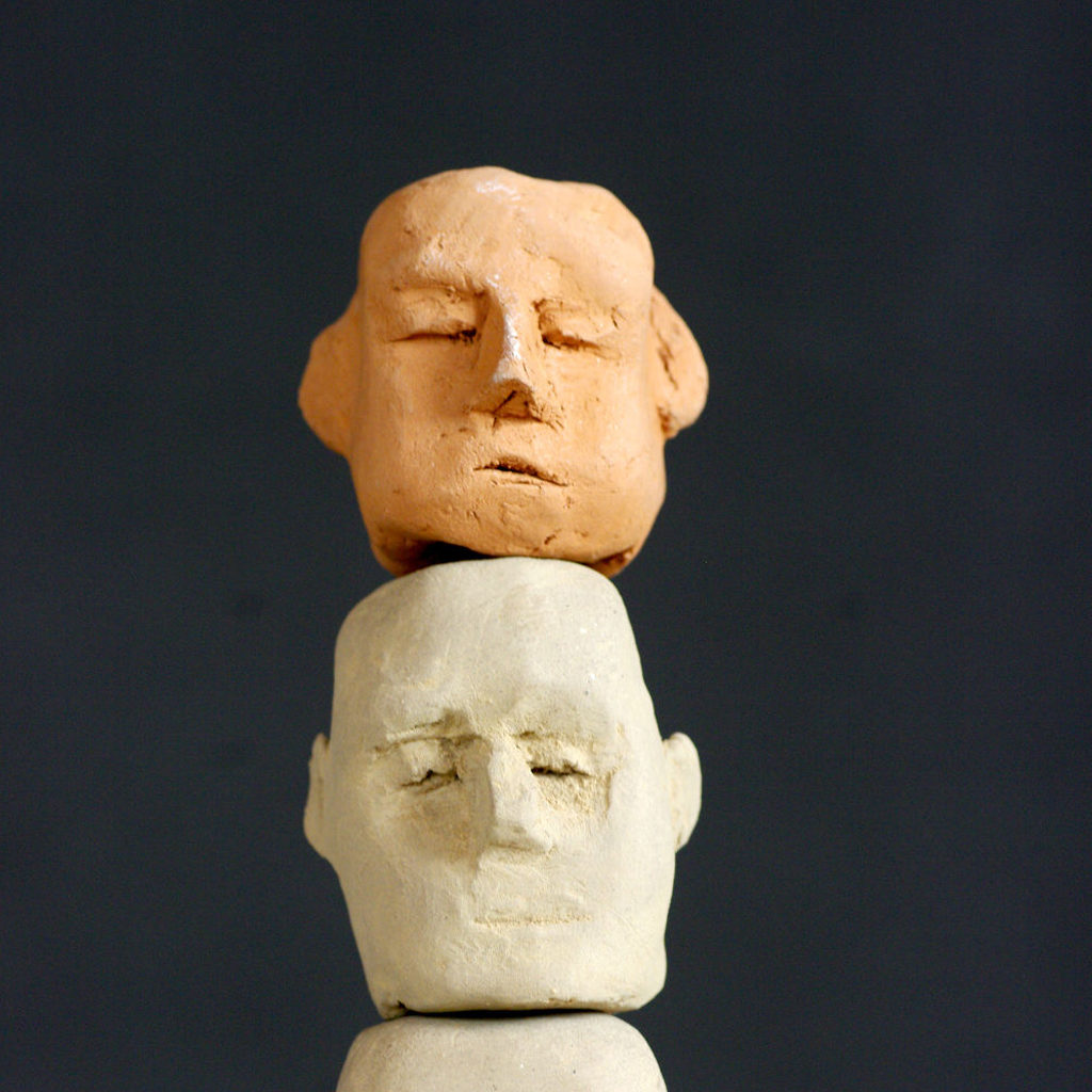 Deux têtes de terre cuite en totem. Sculpture de Philippe Doberset