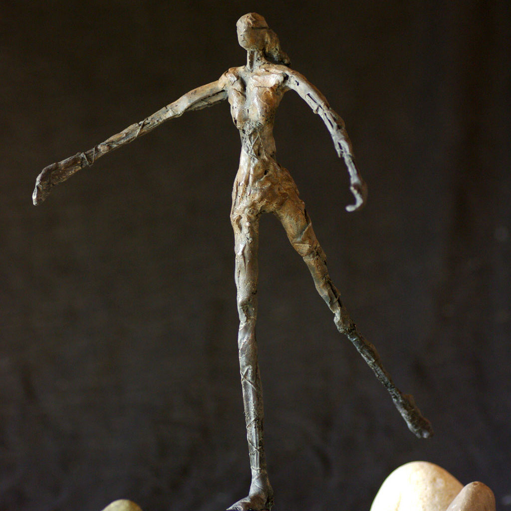 Petite fille en bronze sautant de pierre en pierre. Sculpture de Philippe Doberset