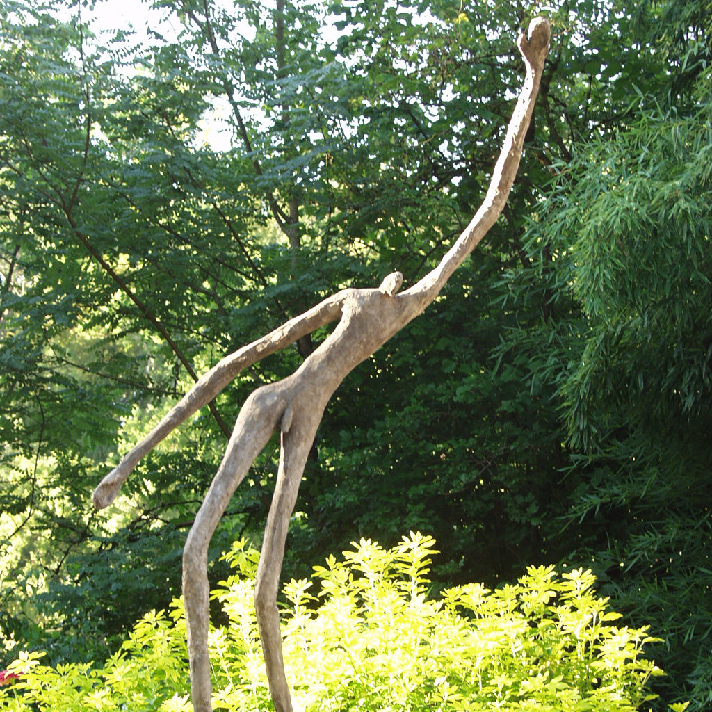 Grand personnage en ciment le bras levé. Sculpture de Philippe Doberset