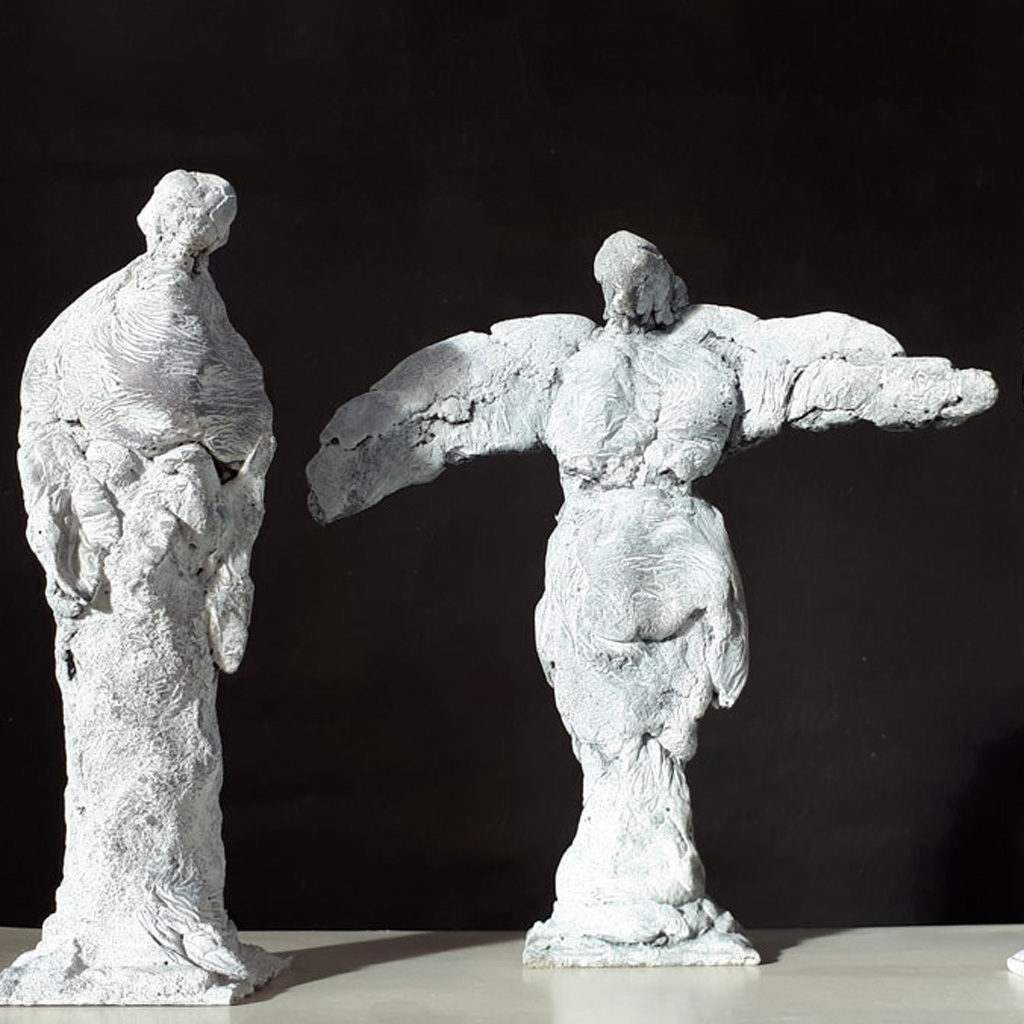 Personnages bras ouverts en ciment blanc. Sculpture de Philippe Doberset