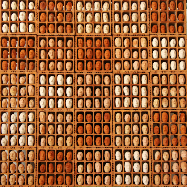 Groupe de personnages en terre cuite installés dans des modules en brique découpées. Sculpture de Philippe Doberset