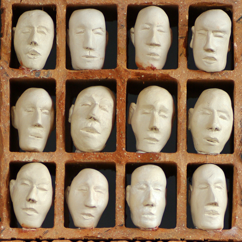 Groupe de personnages en terre cuite installés dans des modules en brique découpées. Sculpture de Philippe Doberset