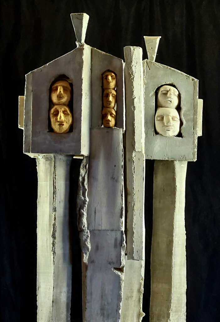 Sculpture de Philippe Doberset comme une architecture anthropomorphe  représentant deux personnages en béton incluant  une série de petites têtes